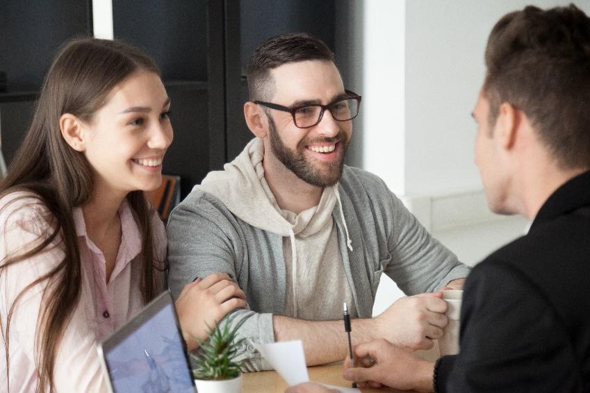 Excited smiling millennial couple discussing mortgage loan